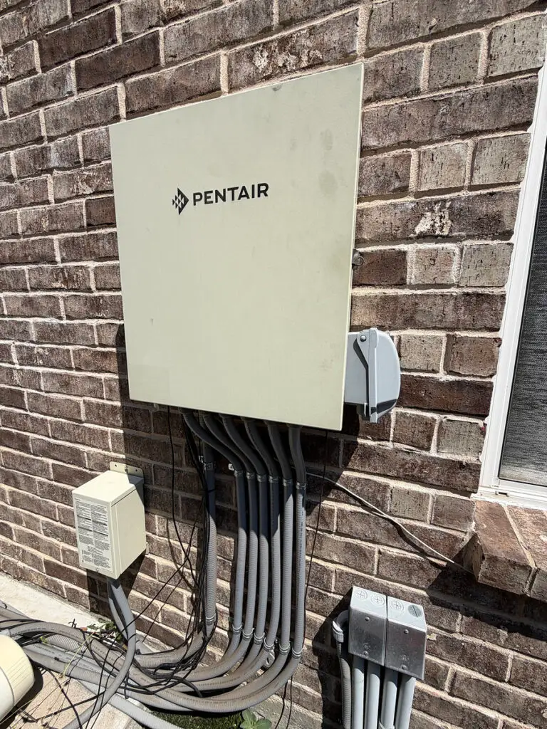 Pentair pool automation control panel mounted on a brick wall